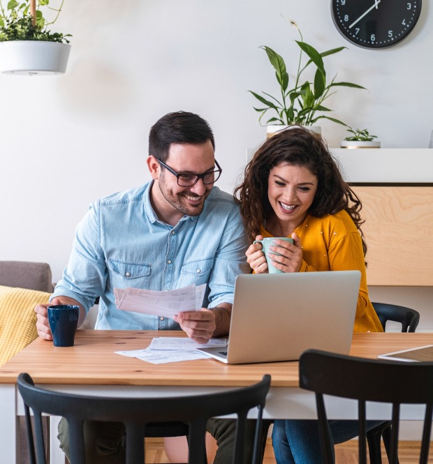 Happy husband and wife read good news online at laptop, smiling man holding documents receiving positive decision from bank stock photo