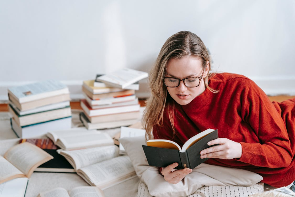 a woman in a red sweater holding a book