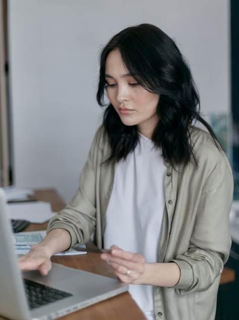  a woman at her desk typing on her computer.