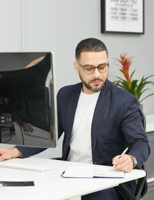 This image shows a man writing on a paper.