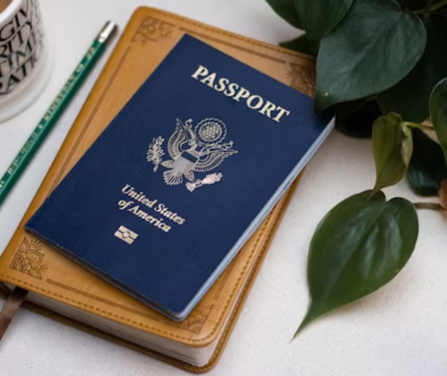 This image shows a passport, diary and pencil lying on a table.