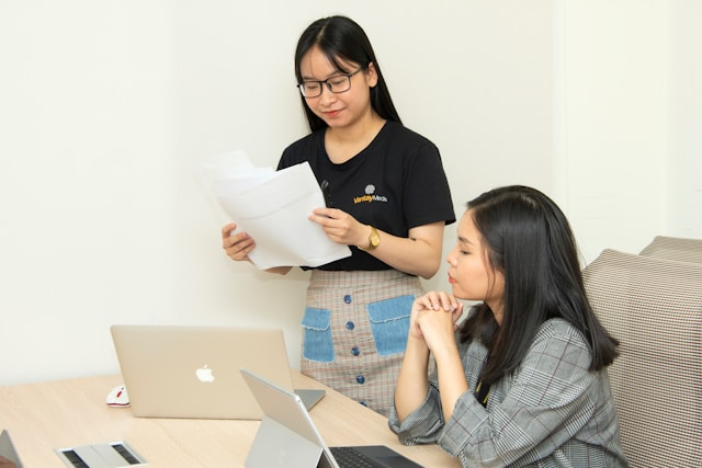 This photo shows two women worried over paper work
