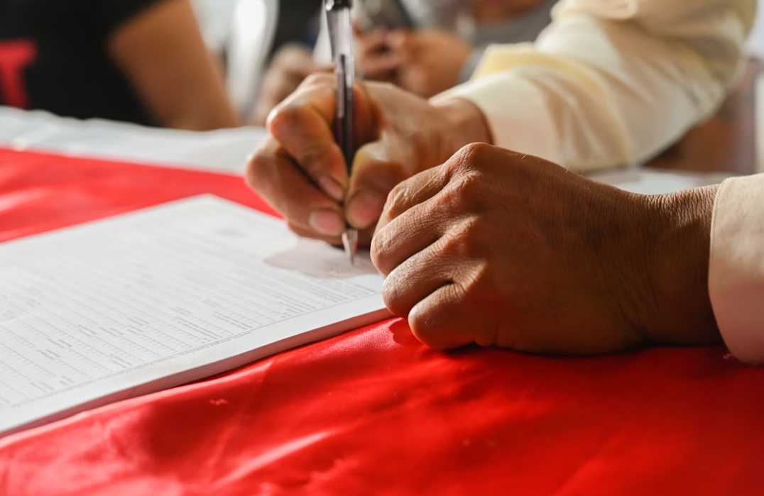This image shows a man signing a certificate.