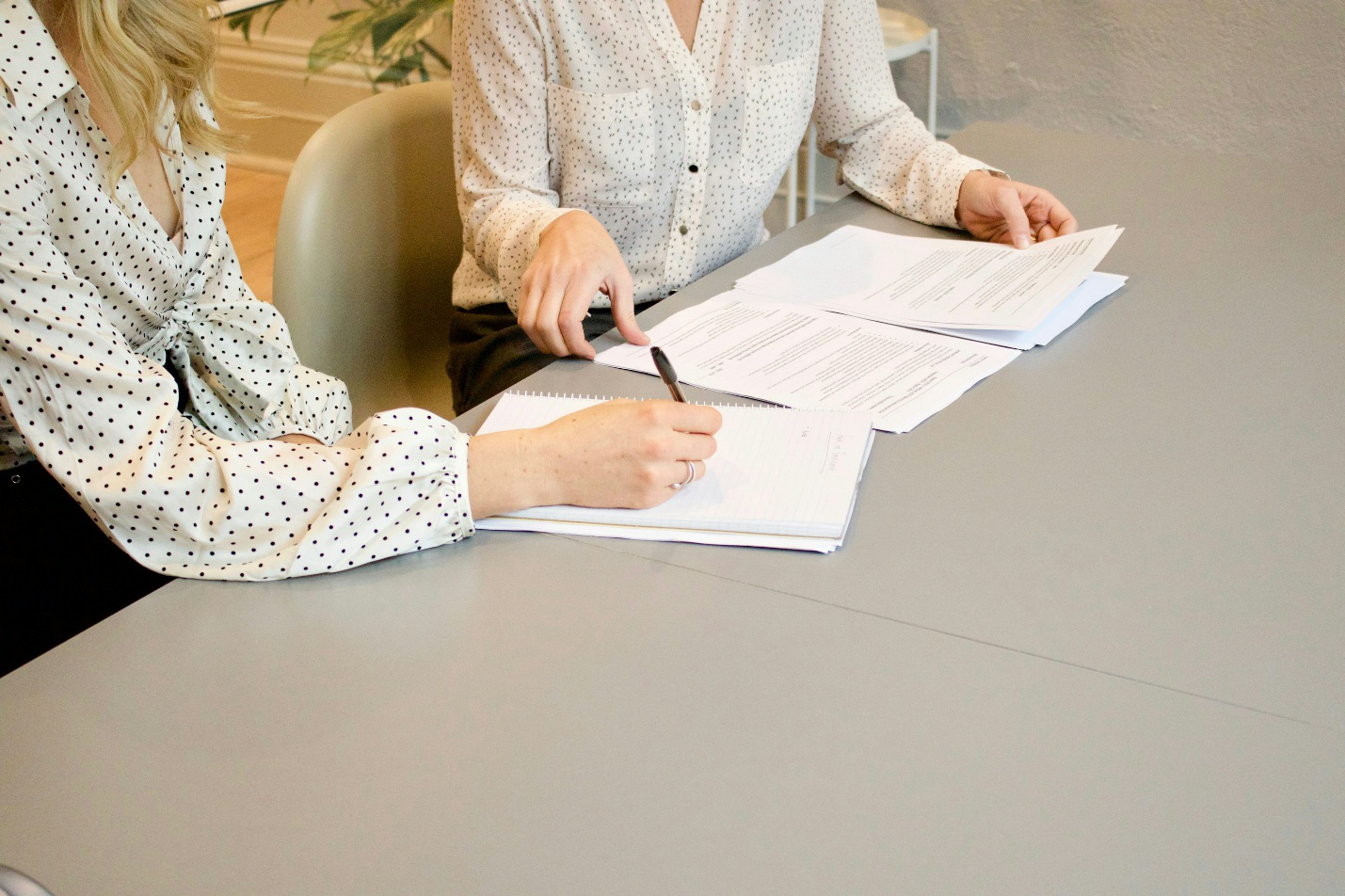 Two women signing documents