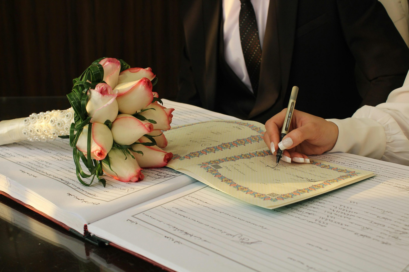 A couple signing their marriage certificate 